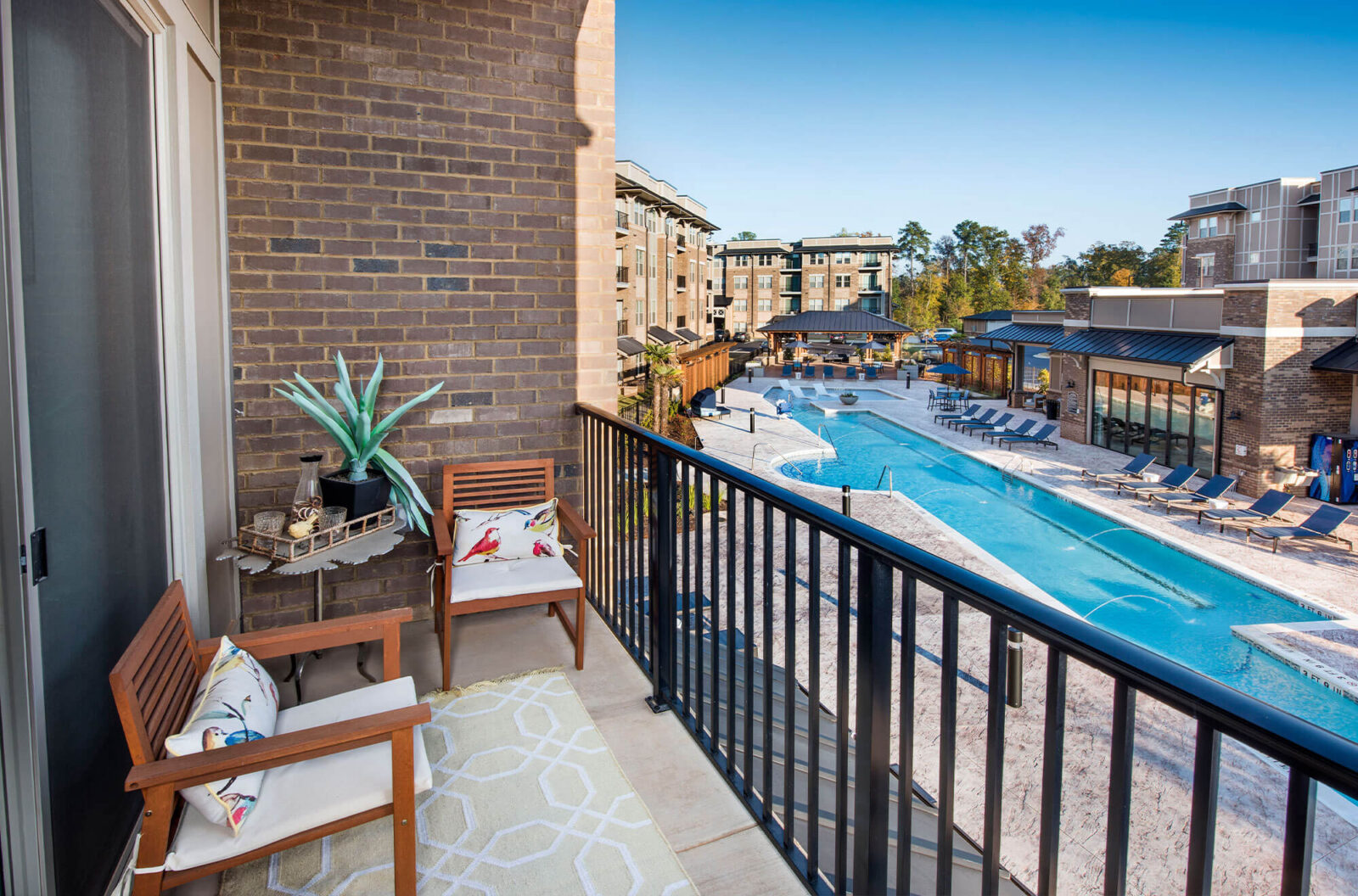 View of Riverwatch from apartment outdoor balcony with view of long beautiful pool.